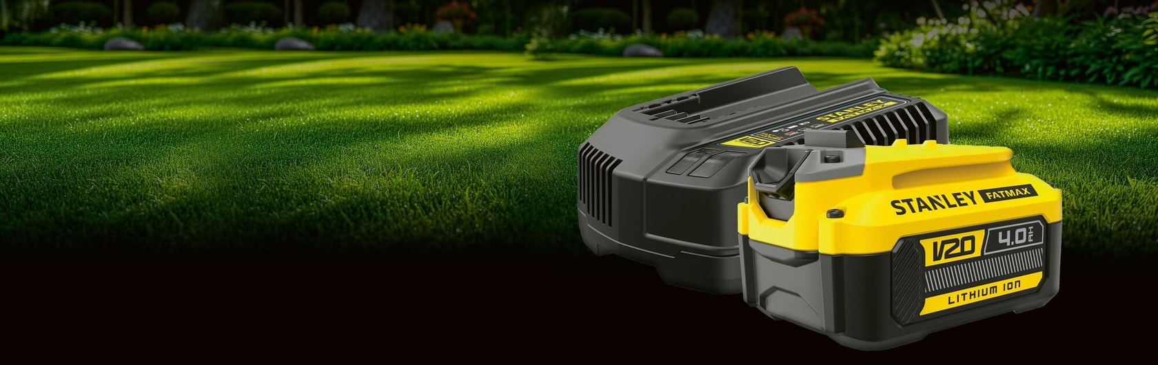 Ein Stanley FATMAX 18V 4,0Ah Lithium-Ionen-Akku und Ladegerät-Set auf einem grünen Rasen im Hintergrund.